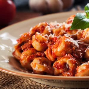 Tortellini with pasta or marinara sauce and fresh basil with shredded parmesan cheese on top as one of the easy dinners in the easiest Aldi meal plan, which delivers 14 dinners to your front door for under $150.