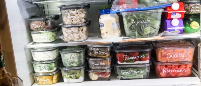 An organized fridge with meal prepped containers after a woman implemented her home management system. 