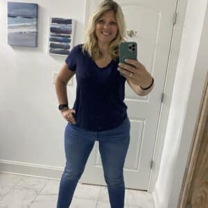 43 year old blonde woman in a navy blue short sleeve shirt and skinny jeans. 
