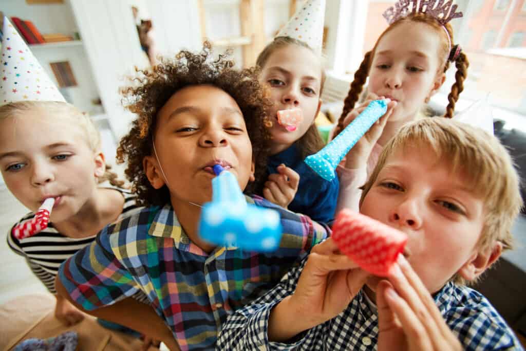 children blowing party horns 