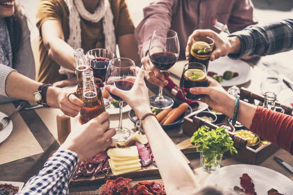 Freinds enjoying food and drinks together at table.