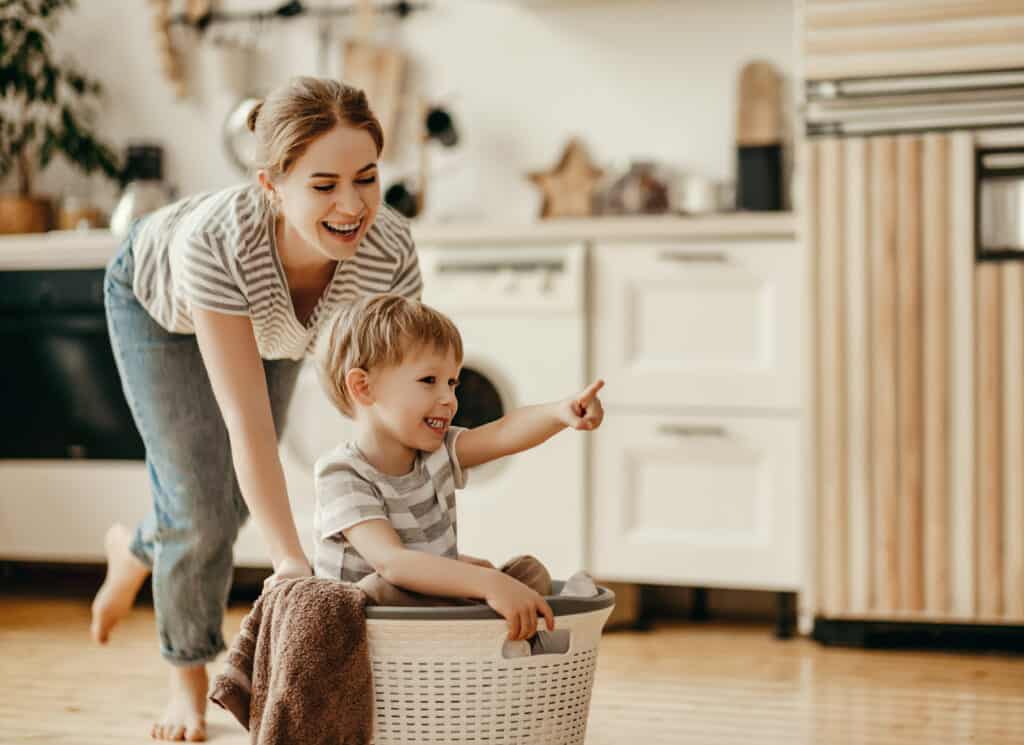 mother and child son in laundry with washing machine