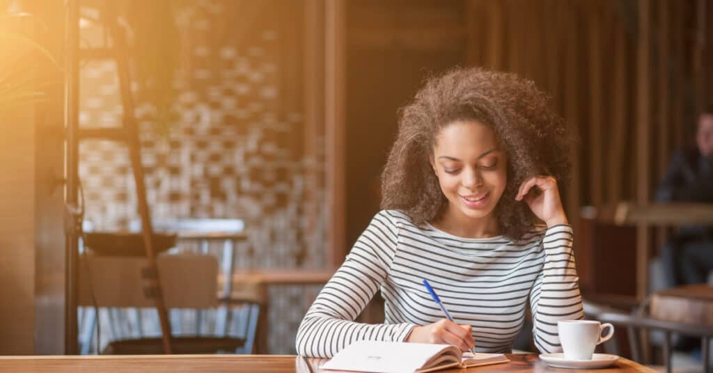 woman writing in her planner during life management challenge