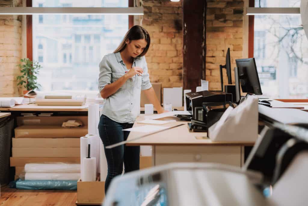 Young woman printing her lables in her return online purchase area.