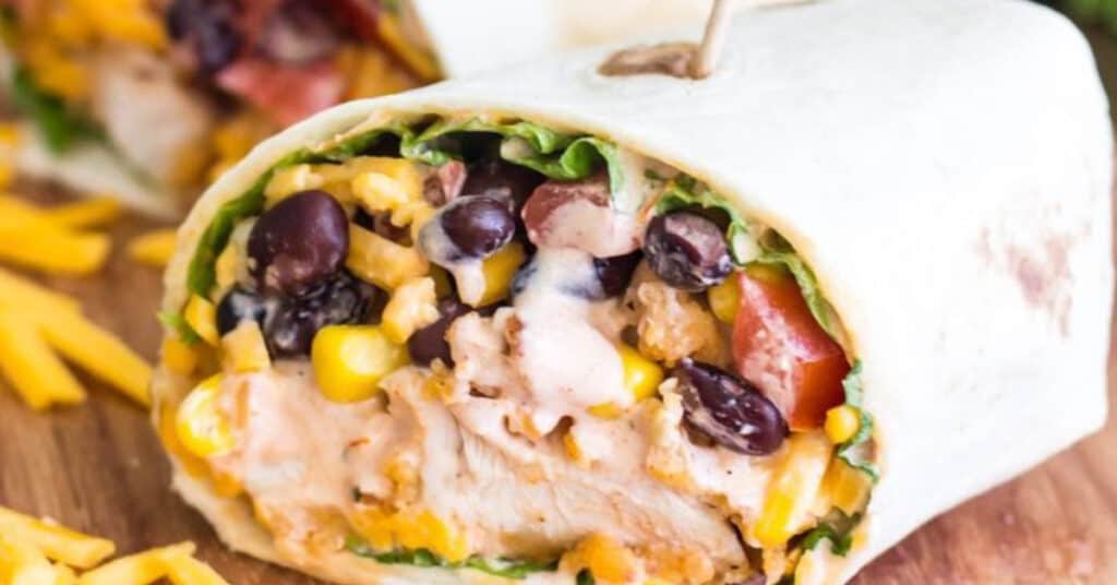 Wraps stuffed with chicken tenders, black beans, lettuce, tomatoes and liquid gold sauce. easy Monday night dinners.