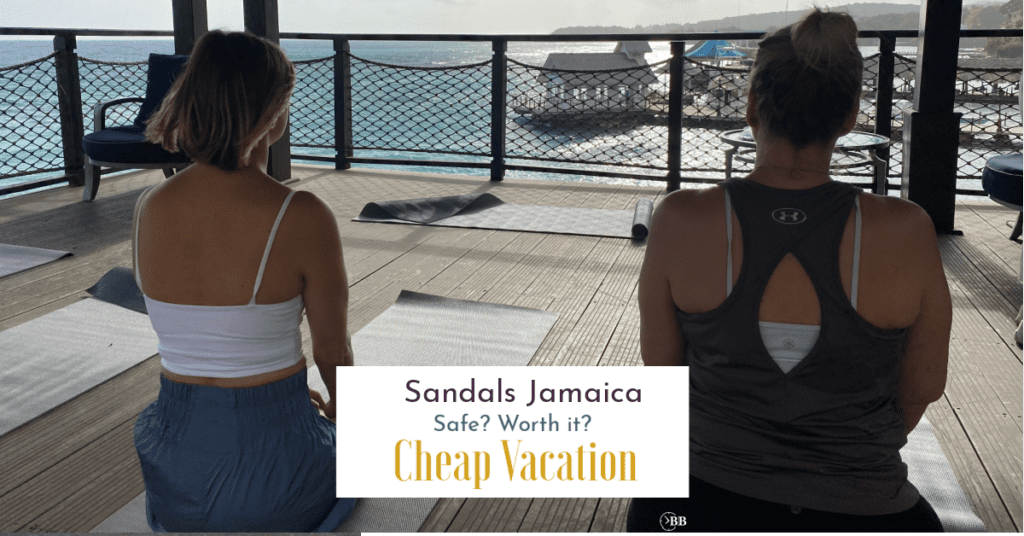 Two women sittinging on yoga mats staring out into the ocean at Sandals Ochi